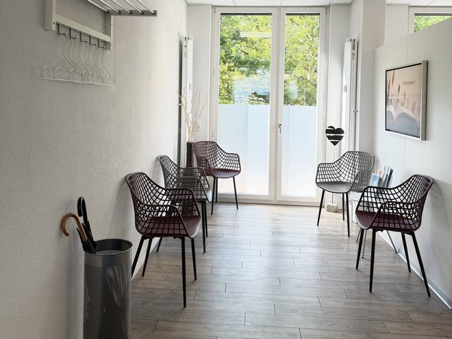 Das Wartezimmer der Podologie Bümpliz mit Stuhlreihen und Blick in den Garten